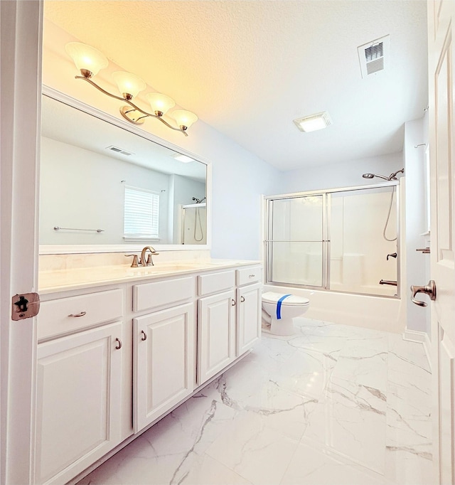 full bathroom with toilet, vanity, shower / bath combination with glass door, and a textured ceiling