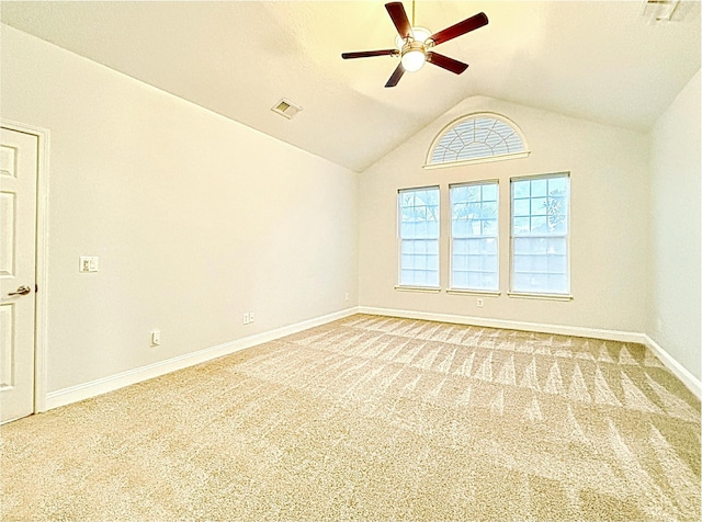 empty room with ceiling fan, light colored carpet, baseboards, lofted ceiling, and visible vents