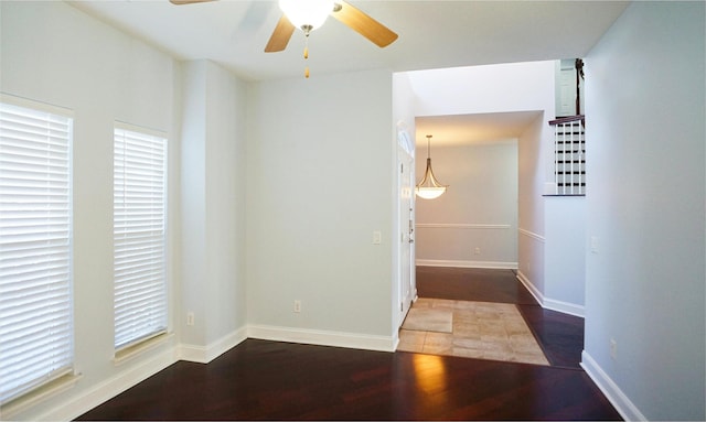 empty room with dark wood-type flooring and ceiling fan