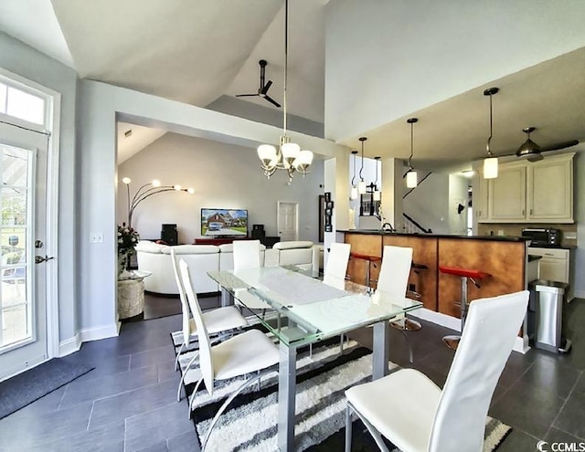 dining area featuring baseboards, vaulted ceiling, dark tile patterned floors, and a chandelier