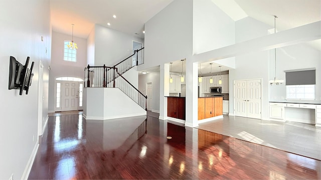 foyer with a notable chandelier, dark hardwood / wood-style floors, and a high ceiling