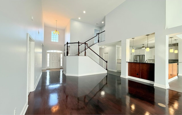 foyer featuring a towering ceiling and dark hardwood / wood-style floors