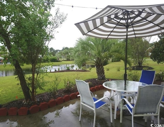 view of patio with outdoor dining space and a water view