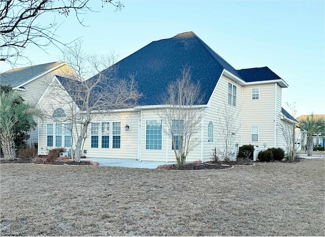rear view of property featuring roof with shingles