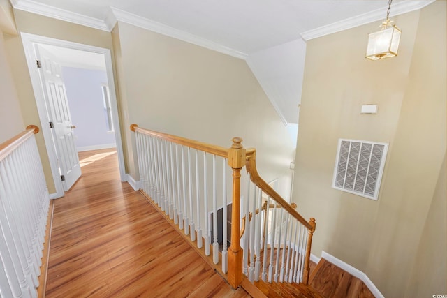 stairway with hardwood / wood-style flooring and ornamental molding