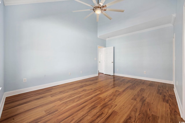 spare room featuring a high ceiling, ornamental molding, hardwood / wood-style floors, and ceiling fan