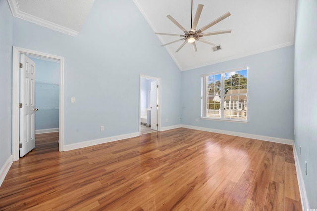 interior space featuring crown molding, hardwood / wood-style floors, high vaulted ceiling, a walk in closet, and a closet