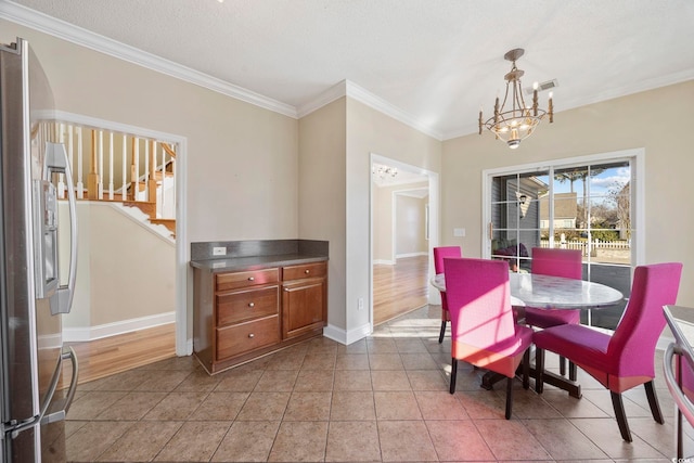 tiled dining area with ornamental molding and an inviting chandelier