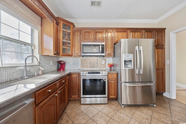 kitchen with stainless steel appliances, light stone countertops, sink, and decorative backsplash