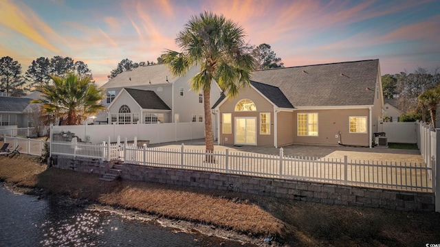 back house at dusk featuring a patio area