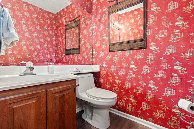 4396 Baldwin Ave Unit 94, Little River, SC 29566 - bathroom featuring wood finished floors, vanity, baseboards, toilet, and wallpapered walls