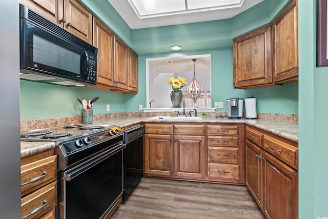 4396 Baldwin Ave Unit 94, Little River, SC 29566 - kitchen with black appliances, a sink, wood finished floors, brown cabinets, and light countertops