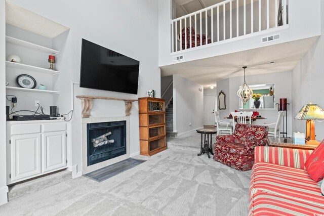 4396 Baldwin Ave Unit 94, Little River, SC 29566 - living area featuring light colored carpet, a tiled fireplace, a towering ceiling, and baseboards