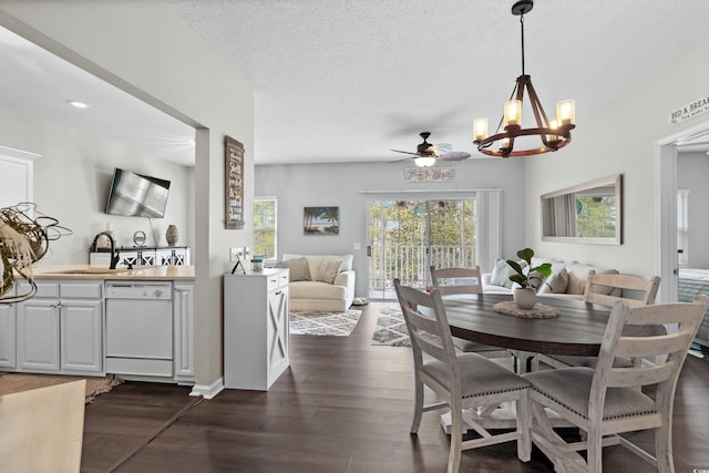 dining space with an inviting chandelier, sink, dark wood-type flooring, and a textured ceiling