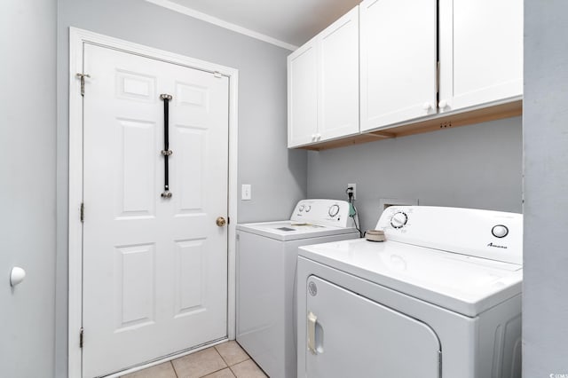 laundry room featuring cabinets, light tile patterned flooring, washing machine and clothes dryer, and crown molding