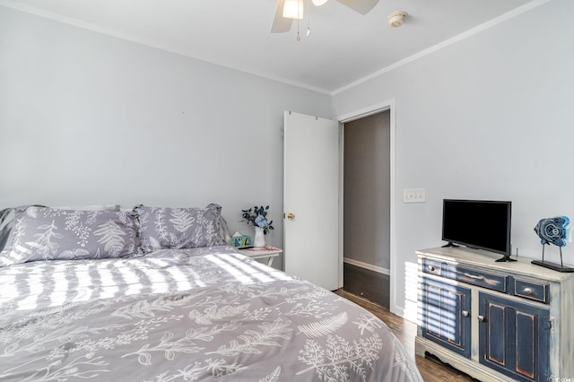 bedroom with dark wood-type flooring, ceiling fan, and crown molding