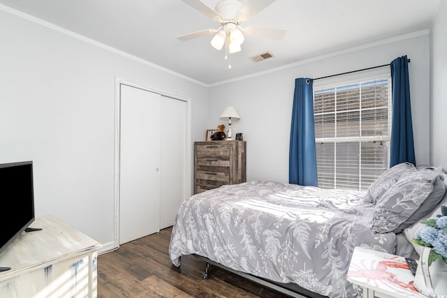 bedroom featuring ornamental molding, ceiling fan, dark hardwood / wood-style flooring, and a closet