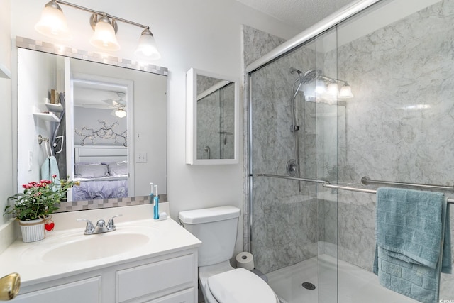 bathroom featuring ceiling fan, vanity, toilet, and a shower with door