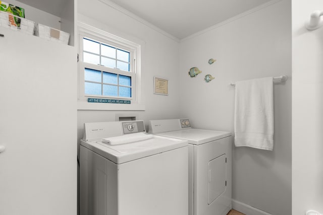 laundry room with ornamental molding, laundry area, separate washer and dryer, and baseboards