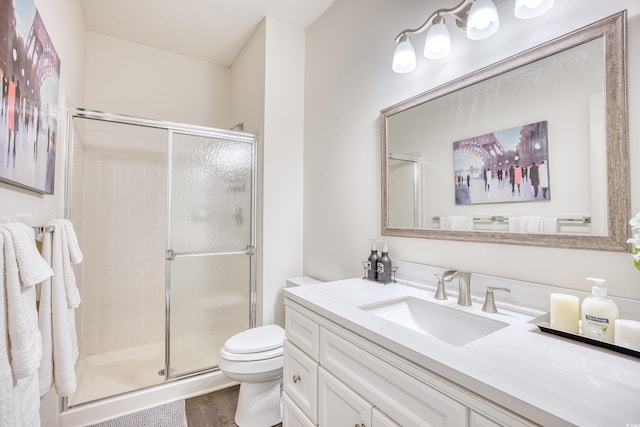 bathroom featuring walk in shower, vanity, toilet, and hardwood / wood-style floors