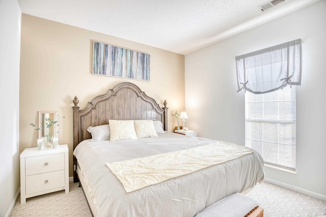 bedroom with light carpet and a textured ceiling