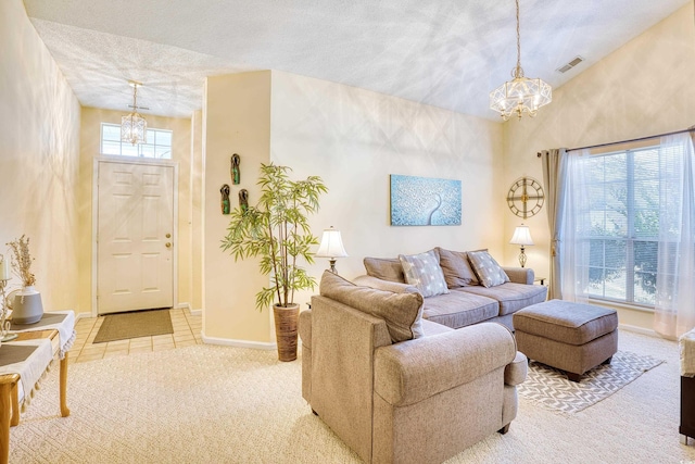 living room with light carpet, a notable chandelier, and a textured ceiling