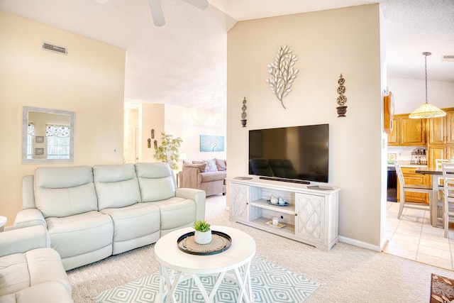 living room with ceiling fan, lofted ceiling, light carpet, and a textured ceiling