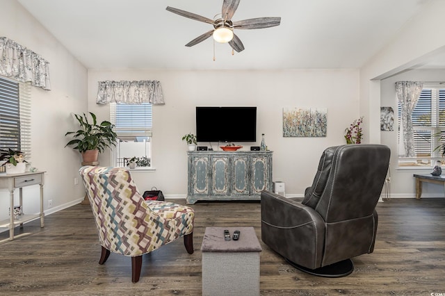 living room featuring dark wood-type flooring, ceiling fan, and a wealth of natural light