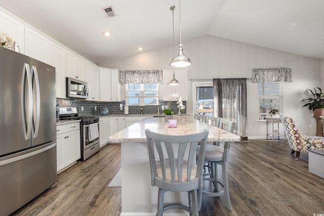 kitchen with stainless steel appliances, hanging light fixtures, a center island, and white cabinets