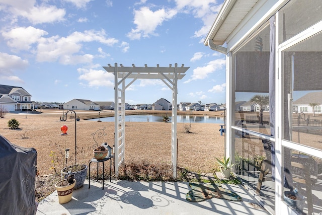 exterior space with a pergola, grilling area, and a water view