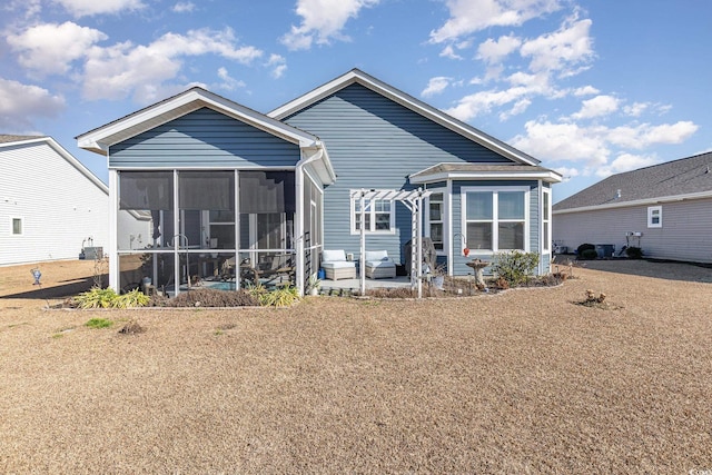 back of house featuring a lawn, a sunroom, and a patio