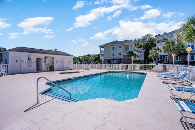 pool with a patio area and fence