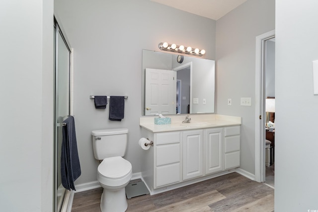 full bath with baseboards, toilet, wood finished floors, vanity, and a shower stall