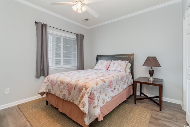 bedroom featuring ornamental molding, wood finished floors, and baseboards