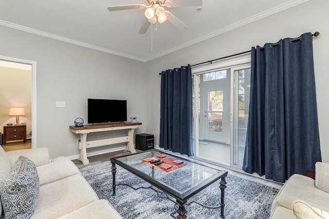 living area featuring ceiling fan, ornamental molding, baseboards, and wood finished floors