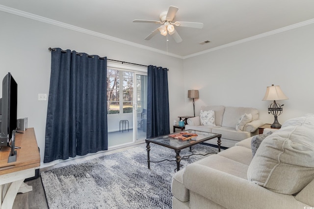 living room featuring ornamental molding, visible vents, ceiling fan, and wood finished floors