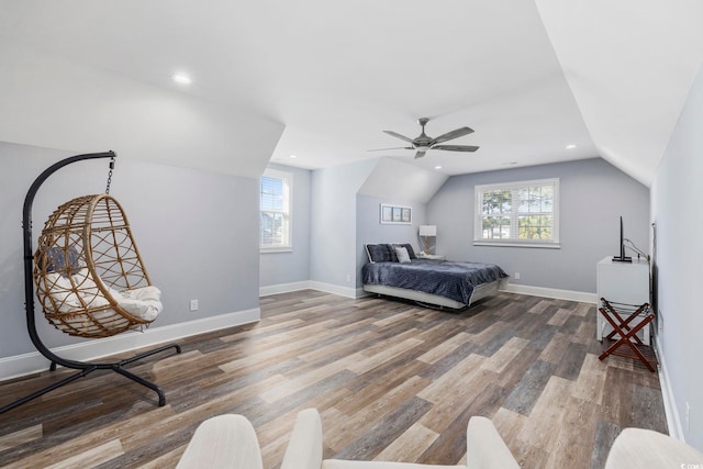 bedroom featuring ceiling fan, lofted ceiling, wood-type flooring, and multiple windows