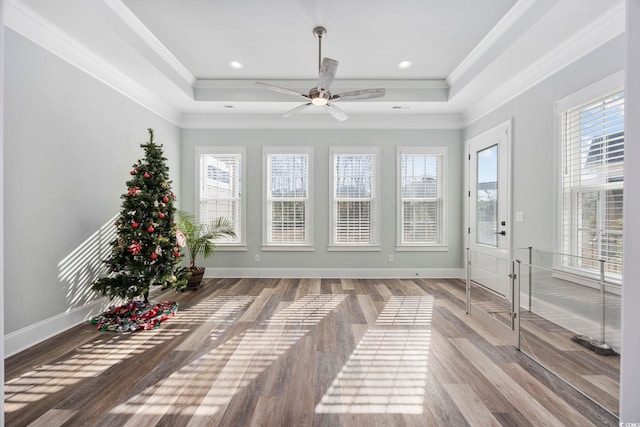 unfurnished sunroom featuring ceiling fan and a raised ceiling