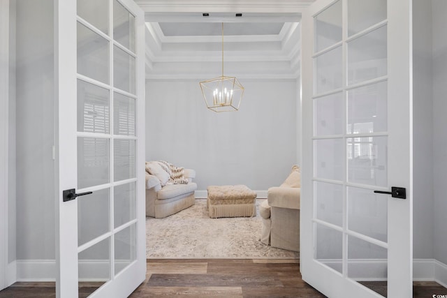 sitting room with ornamental molding, dark hardwood / wood-style floors, a notable chandelier, and french doors