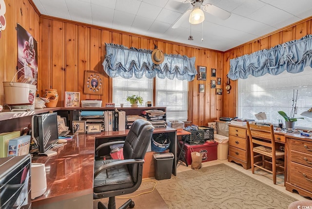 home office with wood walls, crown molding, and a ceiling fan