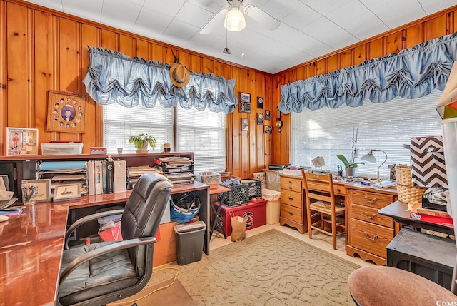 office space with ceiling fan and wood walls