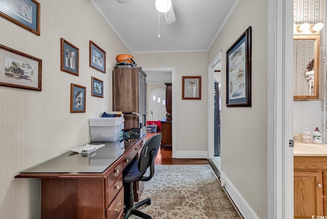 home office featuring baseboards, a sink, a ceiling fan, and crown molding