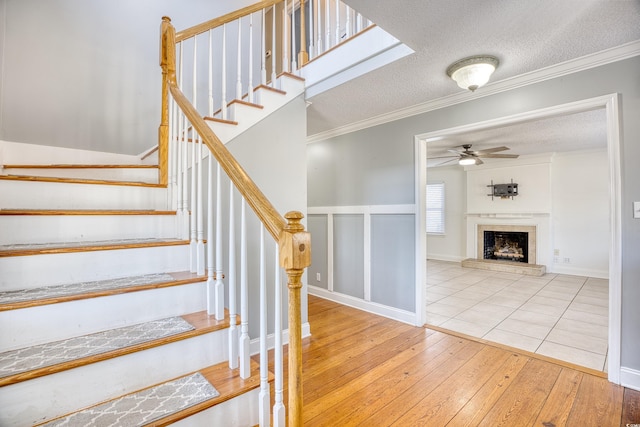 116 Great Lakes Rd, Pawleys Island, SC 29585 - stairway featuring crown molding, wood-type flooring, a textured ceiling, and ceiling fan