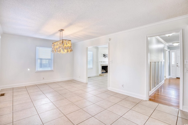 116 Great Lakes Rd, Pawleys Island, SC 29585 - spare room with crown molding, a notable chandelier, a textured ceiling, and light tile patterned floors