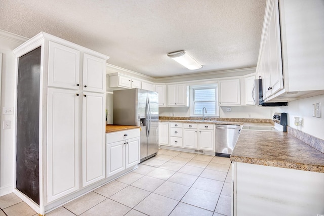 116 Great Lakes Rd, Pawleys Island, SC 29585 - kitchen with sink, white cabinetry, light tile patterned floors, ornamental molding, and appliances with stainless steel finishes