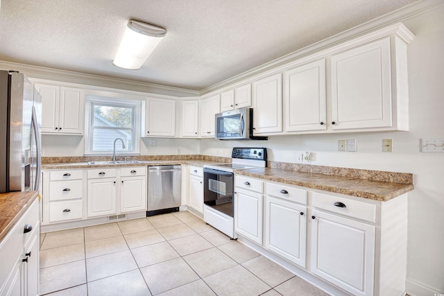 116 Great Lakes Rd, Pawleys Island, SC 29585 - kitchen with light tile patterned flooring, sink, a textured ceiling, stainless steel appliances, and white cabinets