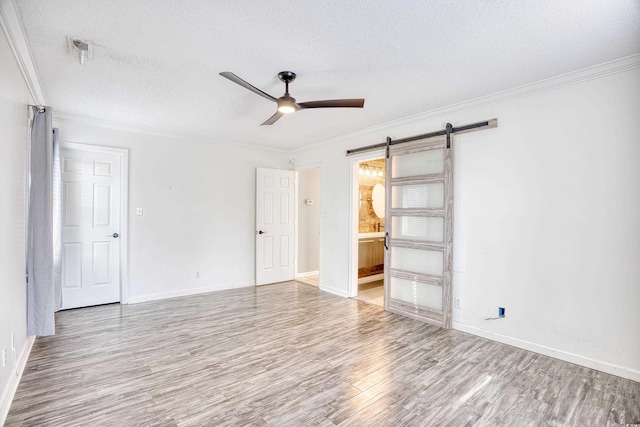 116 Great Lakes Rd, Pawleys Island, SC 29585 - spare room featuring crown molding, a barn door, and light hardwood / wood-style floors
