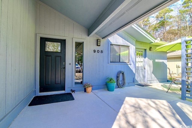 view of exterior entry with a patio area