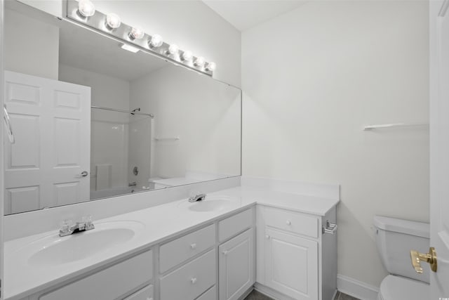 full bathroom featuring washtub / shower combination, vanity, and toilet