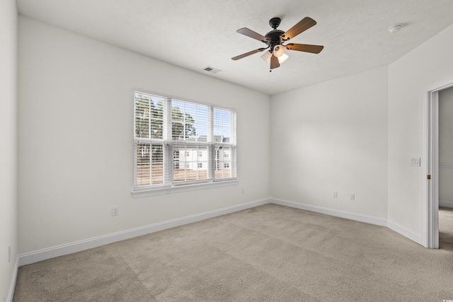 empty room with ceiling fan and light carpet